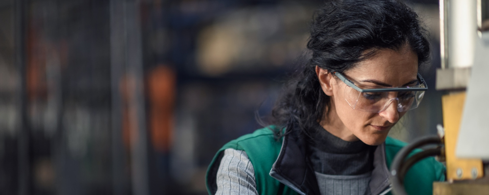 Kvinna med skyddsglasögon i verkstad