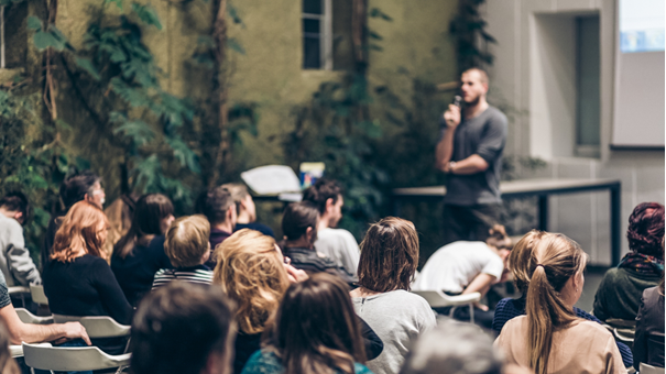 Man som pratar inför grupp