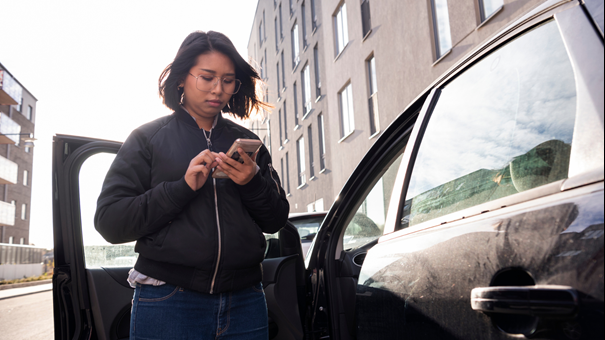 Person betalar parkering med mobilen.