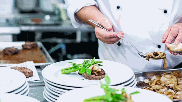 händer som lägger upp mat på fat