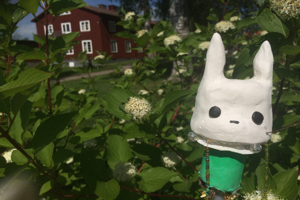 Keramikfigur i förgrunden och skolhus i bakgrunden