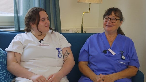 Undersköterskorna Alva och Elisabeth ler mot varandra.