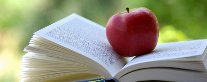 Uppslagen bok med äpple