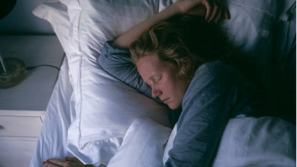 Person sover i en säng.