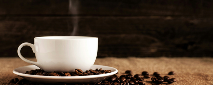 Närbild på kaffekopp på bord. Foto.