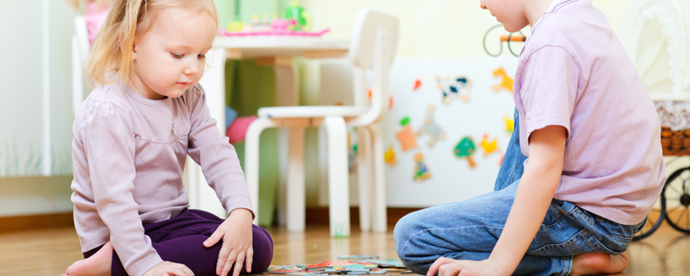 Två barn leker på golvet. Foto.