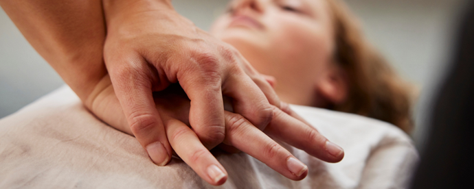 Person övar hjärt-lungräddning på annan person. Foto. 