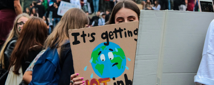 Person håller i plakat. Foto.