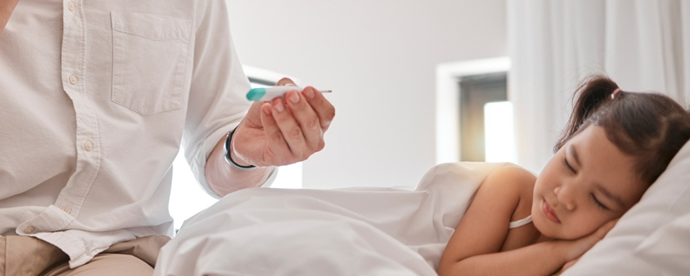 Sjukt barn vilar i sängen. Foto.