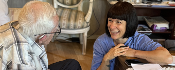 Tandhygienist Jessica Friberg pratar med äldre man i hans hem. Foto.