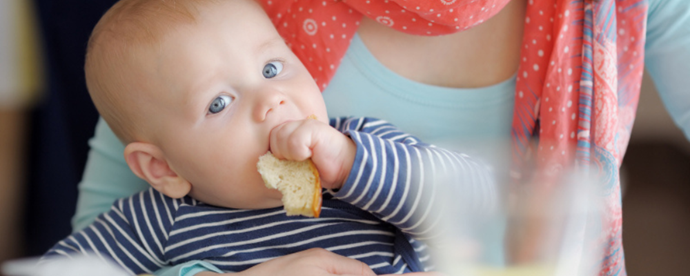 Bebis äter bröd. Foto.